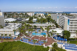 Un hotel de varios pisos, una piscina y vista al mar.