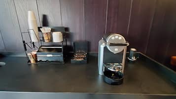 A coffee machine and a paper cup holder on a counter.