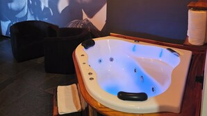Un área de spa con un jacuzzi, asientos oscuros y un cartel grande en la pared.