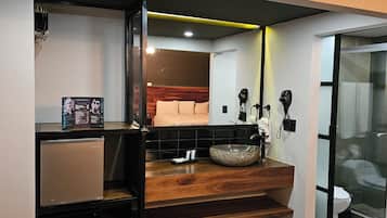 A modern bathroom with a wooden vanity, a large mirror, and a glass shower enclosure.