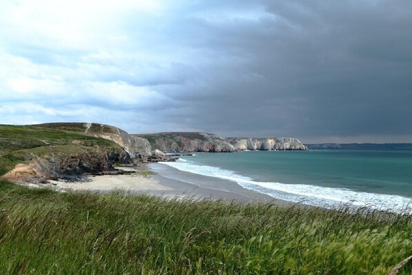 Enjoy a serene beach experience with gentle waves lapping against the shore.