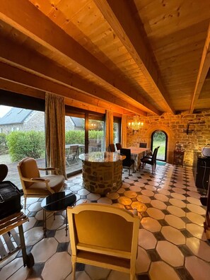 Cozy space with a stone fireplace, round dining table, and comfortable seating area.