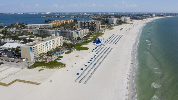 A beachfront hotel with multiple buildings, a sandy beach, and a clear view of the ocean. - St Pete Beach | Couples Gulf Coast Retreat | Pool + Beach (St. Pete Beach)