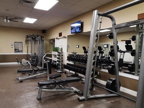 A gym with various exercise equipment, including weight machines and dumbbells.