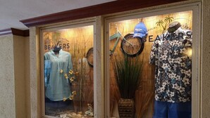 A storefront with mannequins displaying clothing.