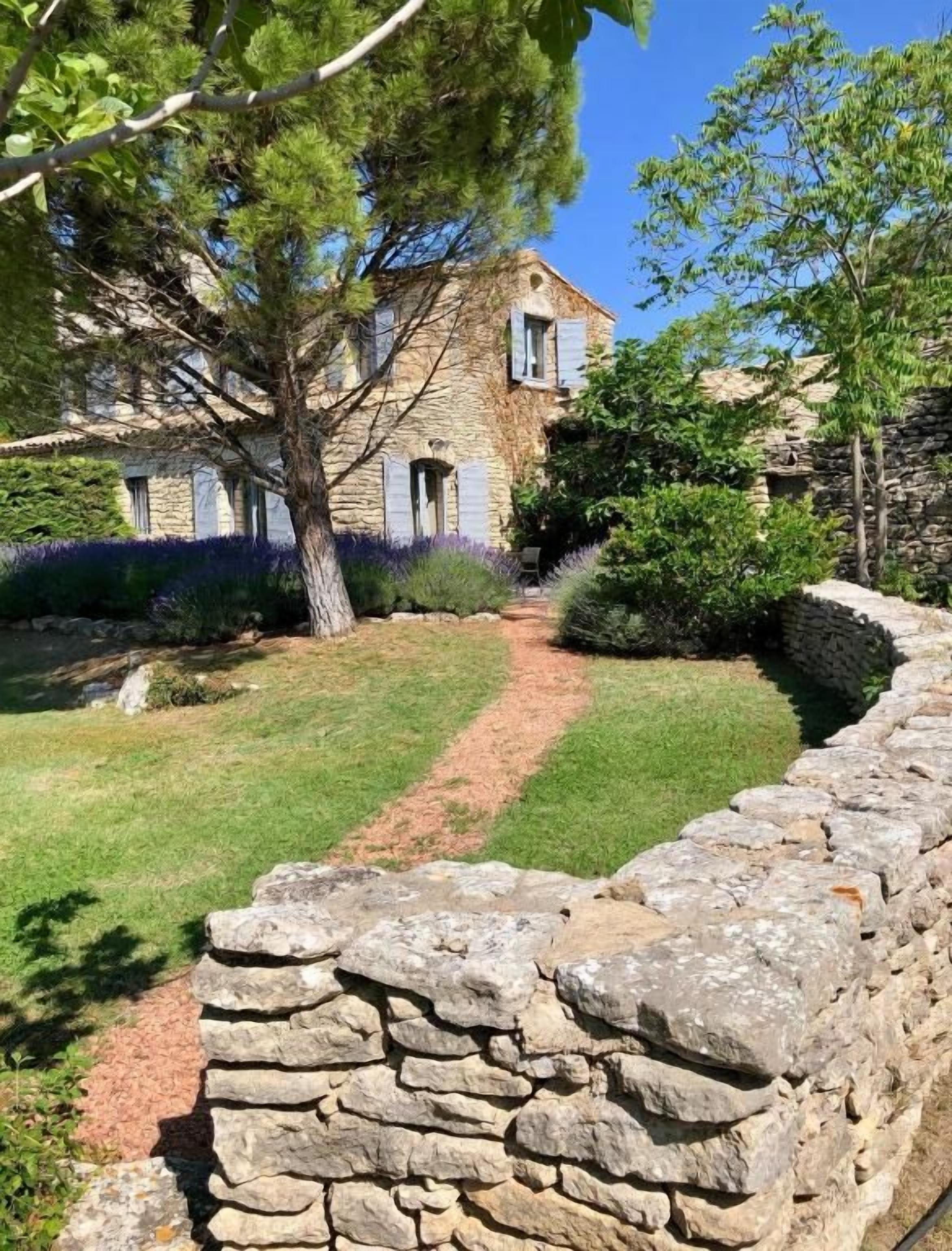 Una casa de piedra con un camino de piedra que lleva a la entrada.