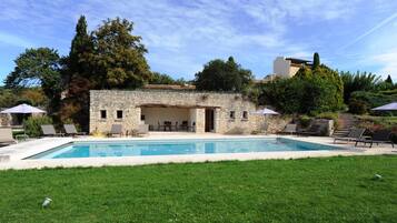 Een seizoensgebonden buitenzwembad, een verwarmd zwembad en ligstoelen