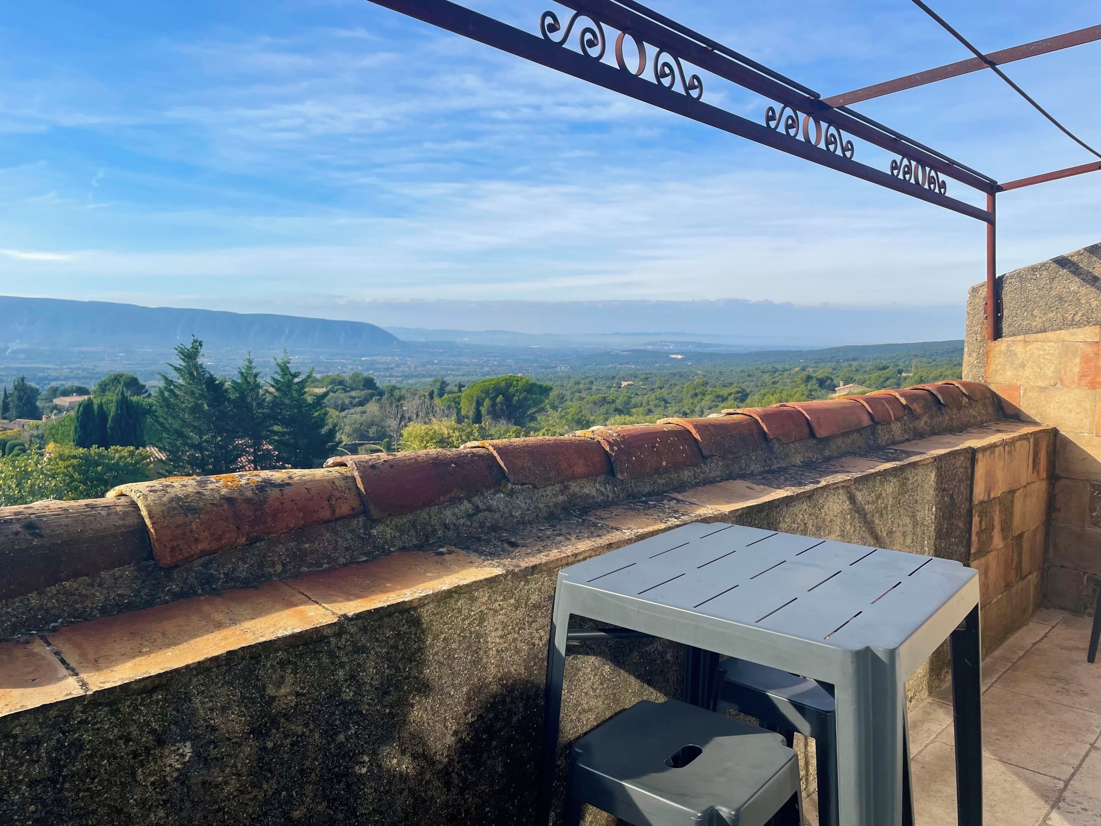 Blick von einem Balkon mit einer Steinmauer und einem Metallgeländer.