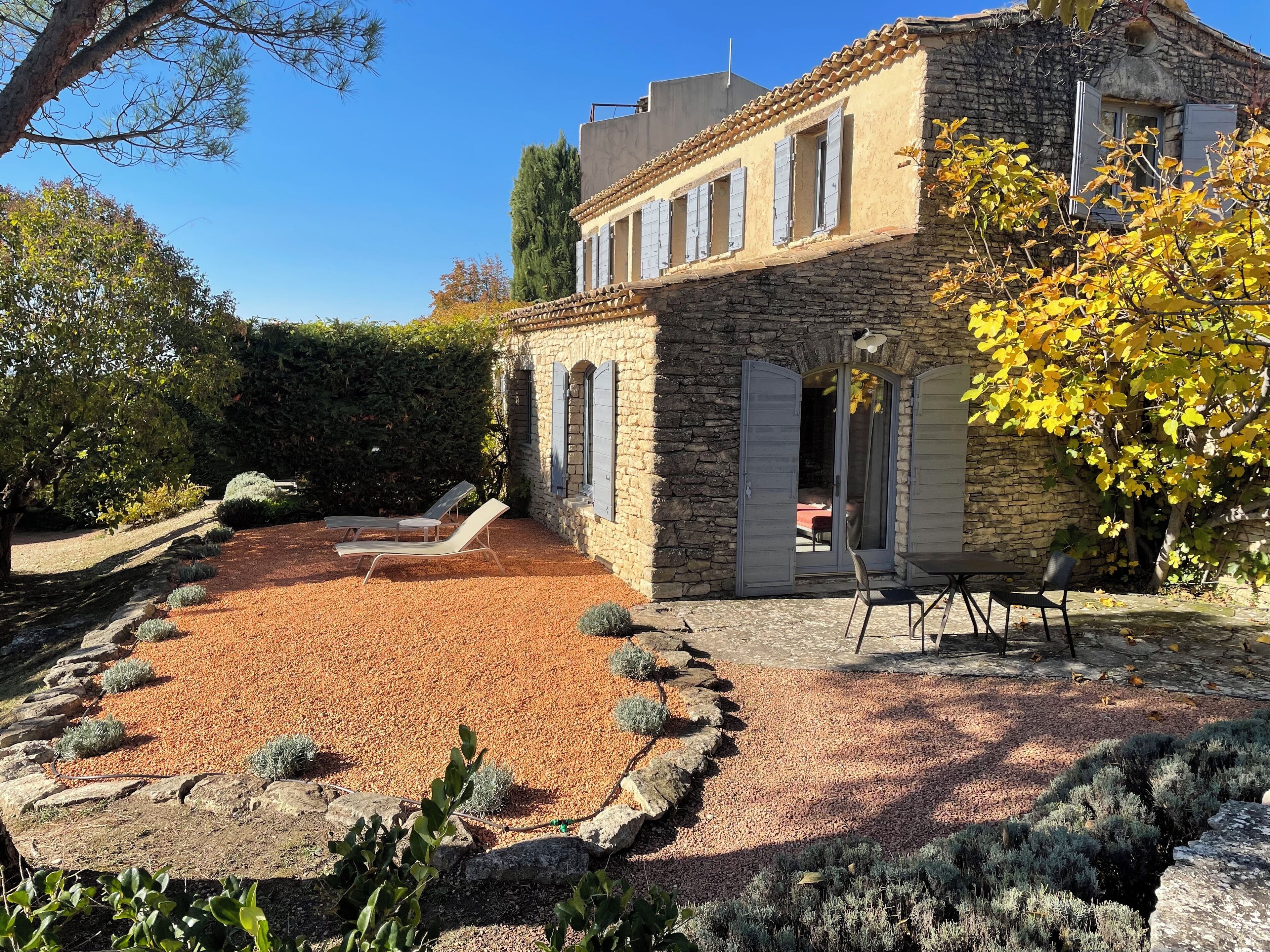 Un bâtiment en pierre doté d’un patio, d’un espace extérieur aménagé pour s’asseoir et d’un jardin.