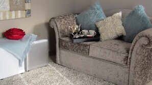A living room with a sofa, a side table, and a decorative bowl. - The Suit Park @ Pentagon (Bloemfontein)
