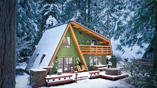 A cabin with a green exterior, a balcony, and a deck area with seating. - Retro A-Frame Chalet, your perfect getaway to Mt.Baker - Hot Tub, Fireplace, A/C (Glacier)