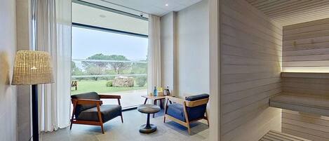 A modern room with a large window, two sofas, a small round table, and a floor lamp.