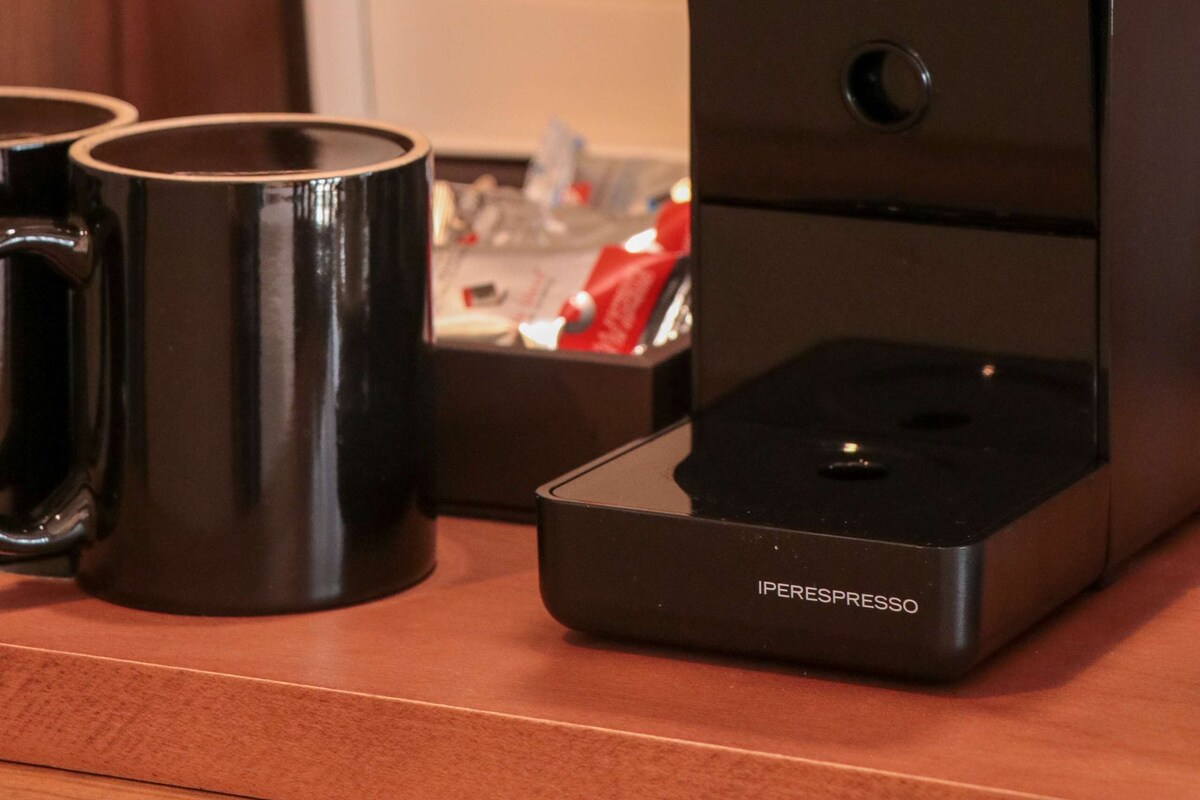 A coffee machine with a control panel and a coffee pod holder.