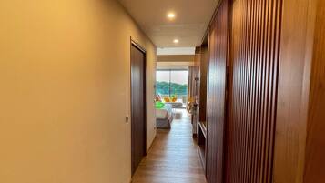 A hallway with wooden paneling on one side and a door at the end.