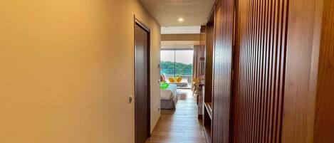 A hallway with wooden paneling on one side and a door at the end.