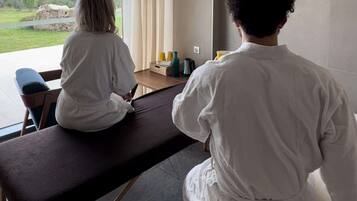 Relax in a serene space with a massage table and a view of the outdoors.
