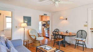 A compact living space with a sofa, a dining table with chairs, a kitchen area, and a ceiling fan. - Beachfront with shared sundeck! (Provincetown)