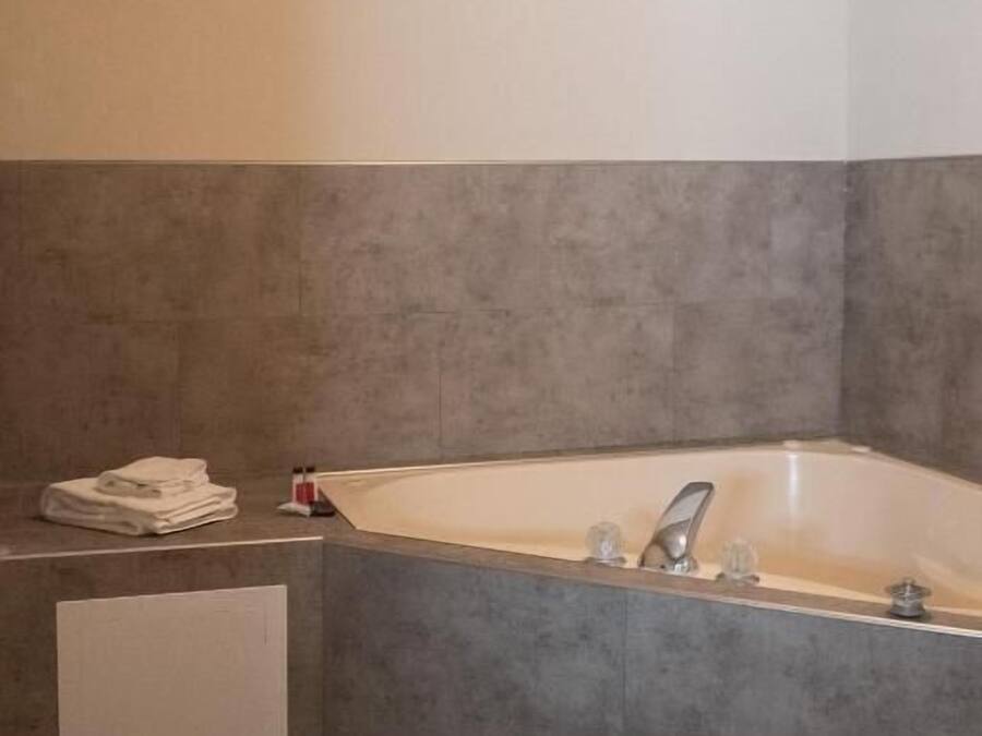 Un baño con una bañera, un perchero para toallas y un armario pequeño.