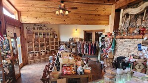 A rustic shop interior with wooden shelves, a variety of handmade soaps, and a display of colorful bags. - Arrowhead Country Cabins (Mount Carmel)