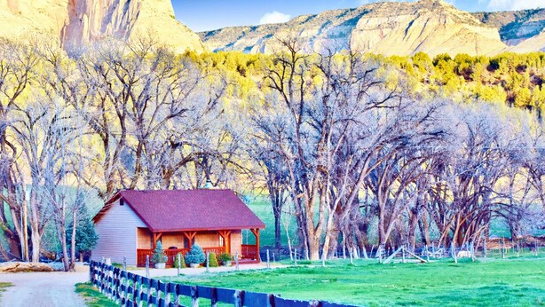 A rustic cabin with a red roof, surrounded by a wooden fence and trees. - Arrowhead Country Cabins (Mount Carmel)