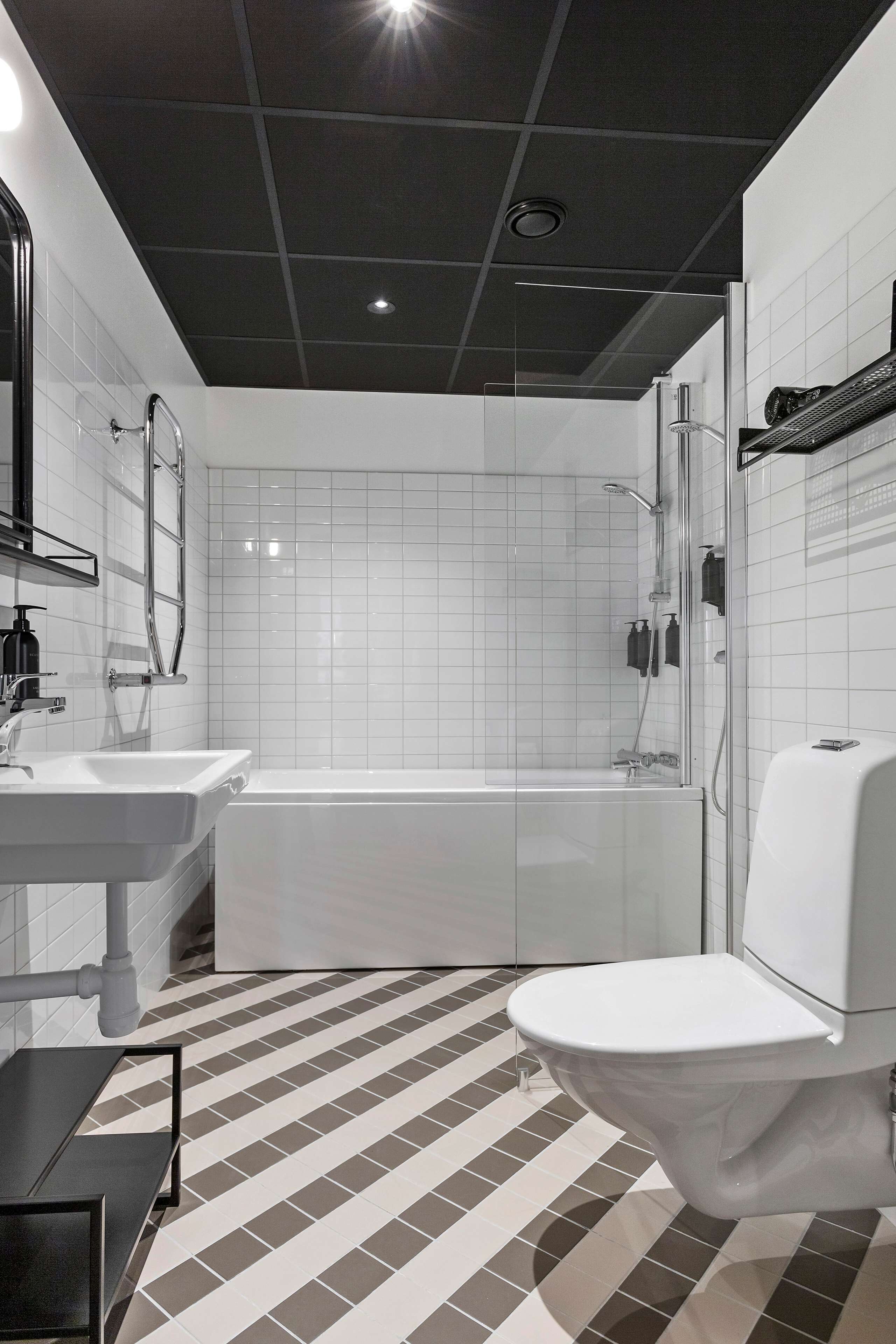 Ein modernes Badezimmer mit einem weißen Waschbecken, einer Toilette und einer Badewanne.