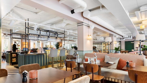 A modern restaurant with a bar area, seating arrangements, and visible kitchen equipment. - Hotel Gio, BW Signature Collection (Solna)