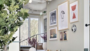 A modern interior with a staircase, wooden flooring, and a large potted plant. - Hotel Gio, BW Signature Collection (Solna)