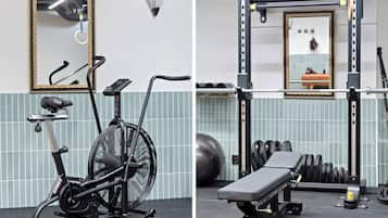Et fitnessrum med en motionscykel, bænk og en squat-stat.