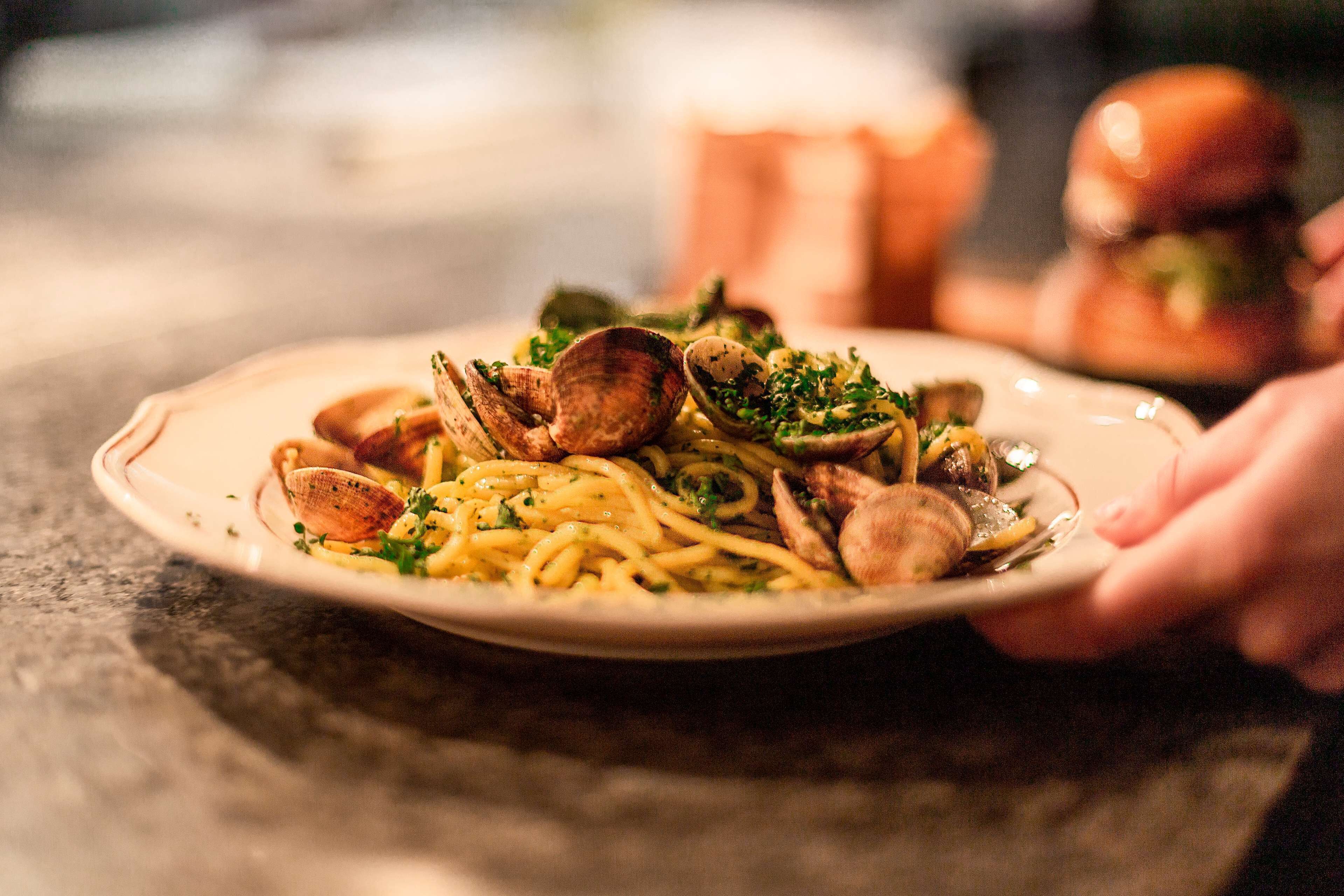 Une assiette de spaghettis aux palourdes et aux herbes.