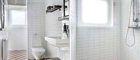 A modern bathroom with a toilet, sink, and shower.