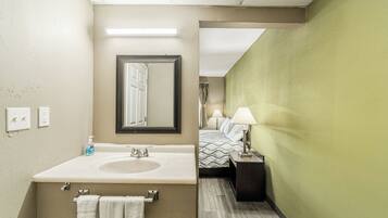 Une salle de bain d’hôtel avec un grand lavabo, un miroir et un porte-serviettes.