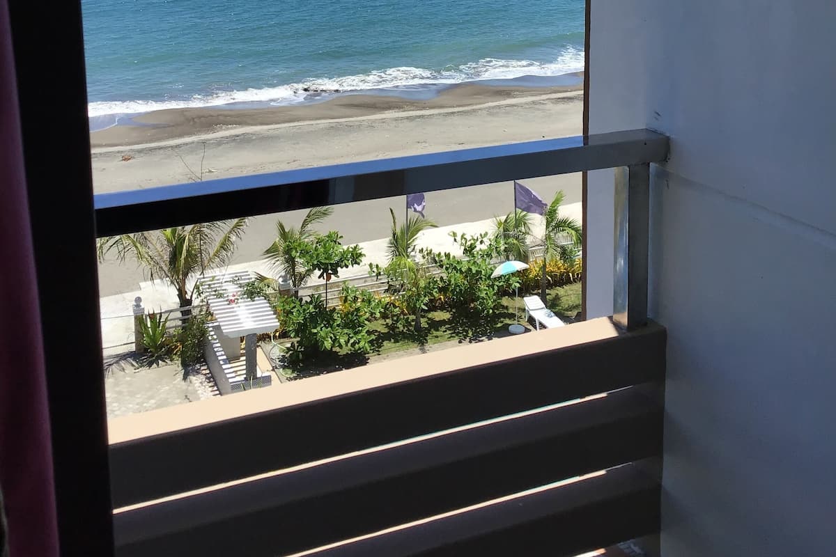 Ein Balkon mit Blick auf das Meer und den Strand.