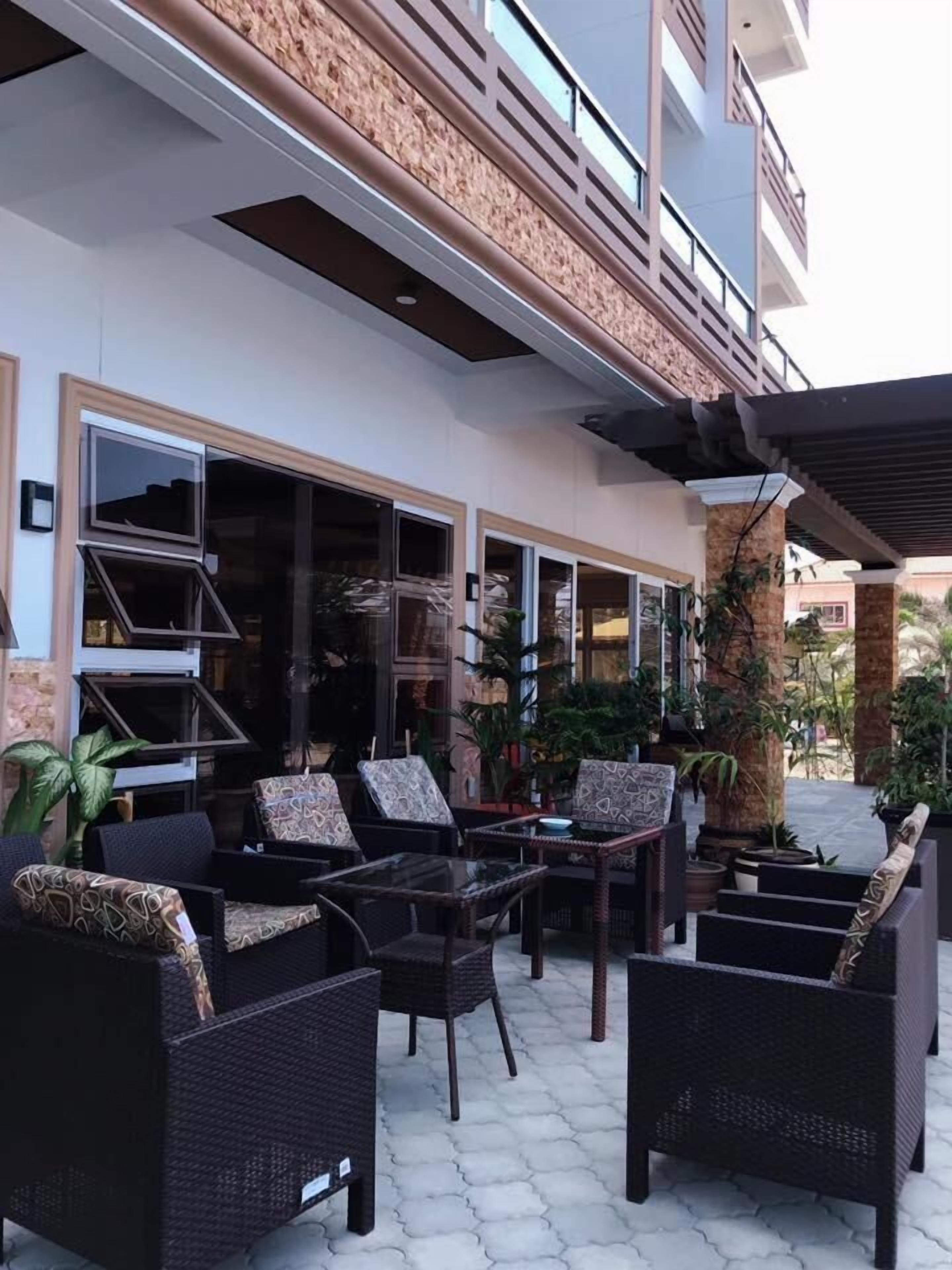An outdoor seating area with wicker furniture and potted plants.