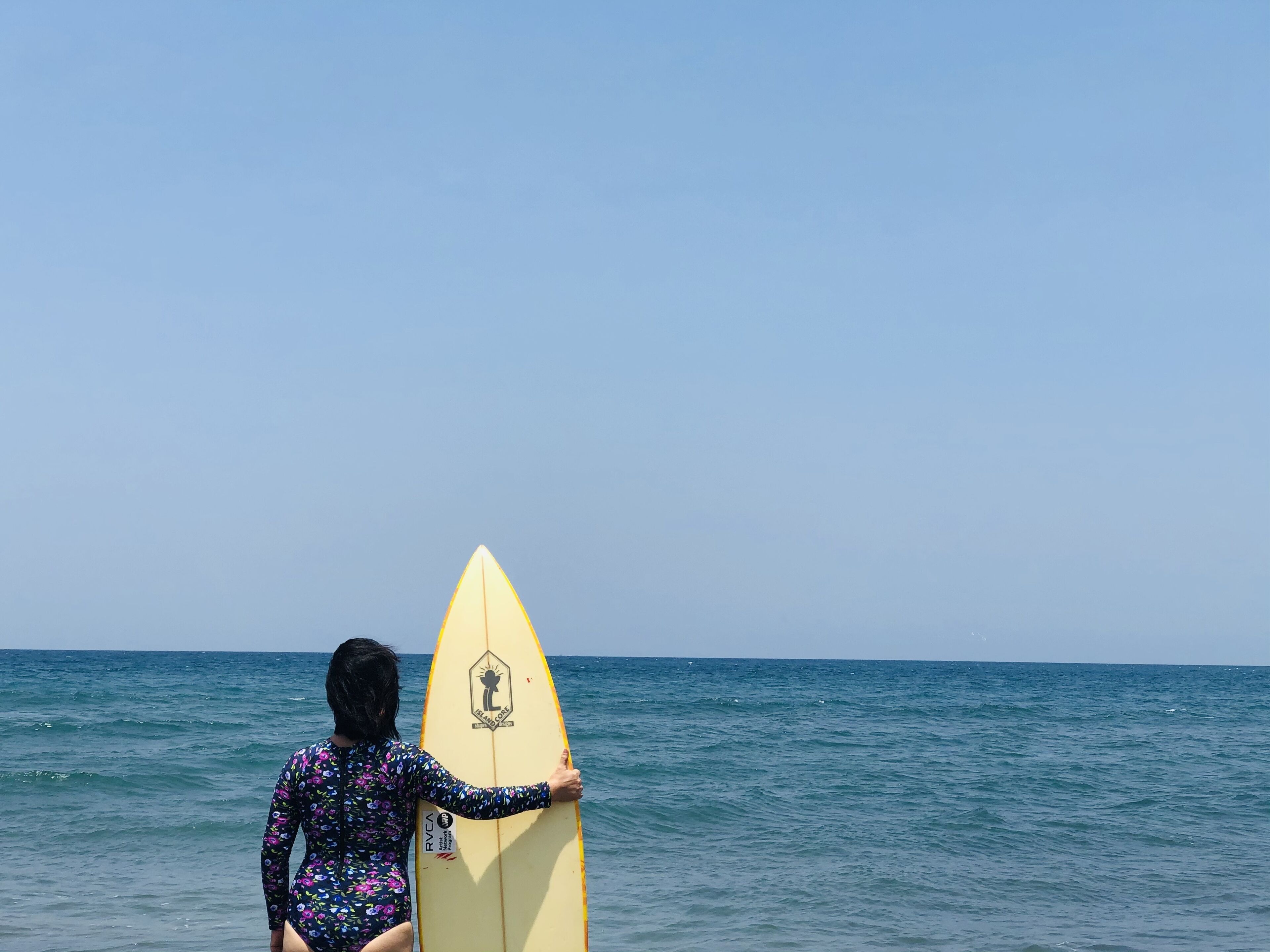 A person holding a surfboard at the beach.