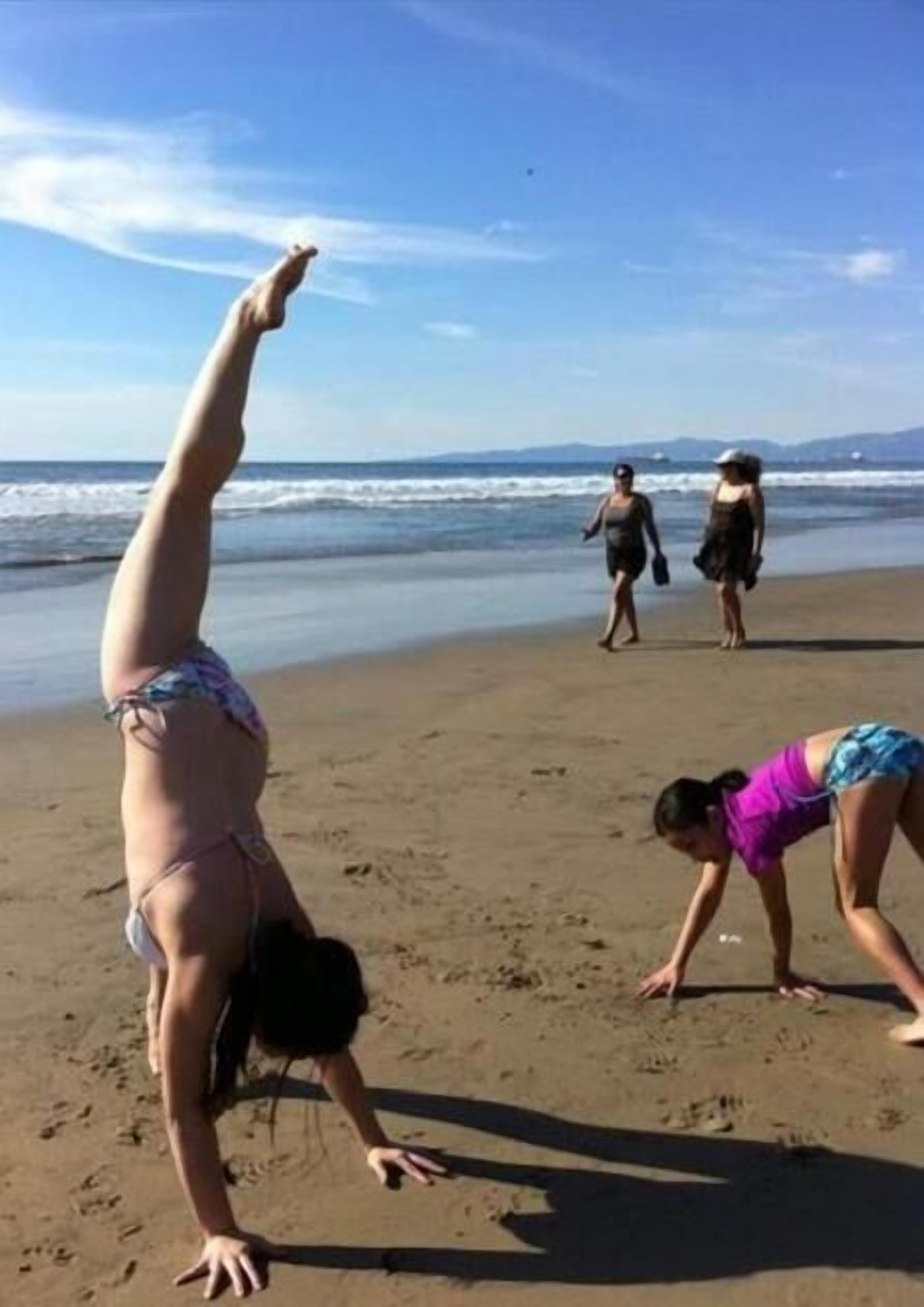A beach scene with people engaging in physical activities.