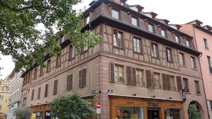 Un edificio storico con una libreria, ampie finestre e una porta rossa.