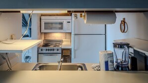 A compact kitchen with a microwave, stove, refrigerator, and a sink. - Sugar Ski Economy Efficiency (no loft) - Unit 11-601 (Sugar Mountain)
