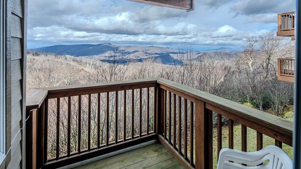 A wooden deck with a view of mountains and trees. - Sugar Ski Economy Efficiency (no loft) - Unit 11-601 (Sugar Mountain)