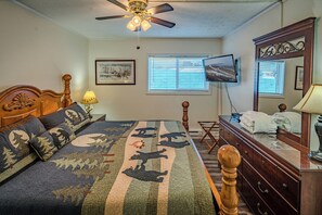 A bedroom with a bed, a wooden dresser, a ceiling fan, a TV, and a window with blinds. - Sugar Ski Deluxe Two Bedroom - Unit 414 (Sugar Mountain)