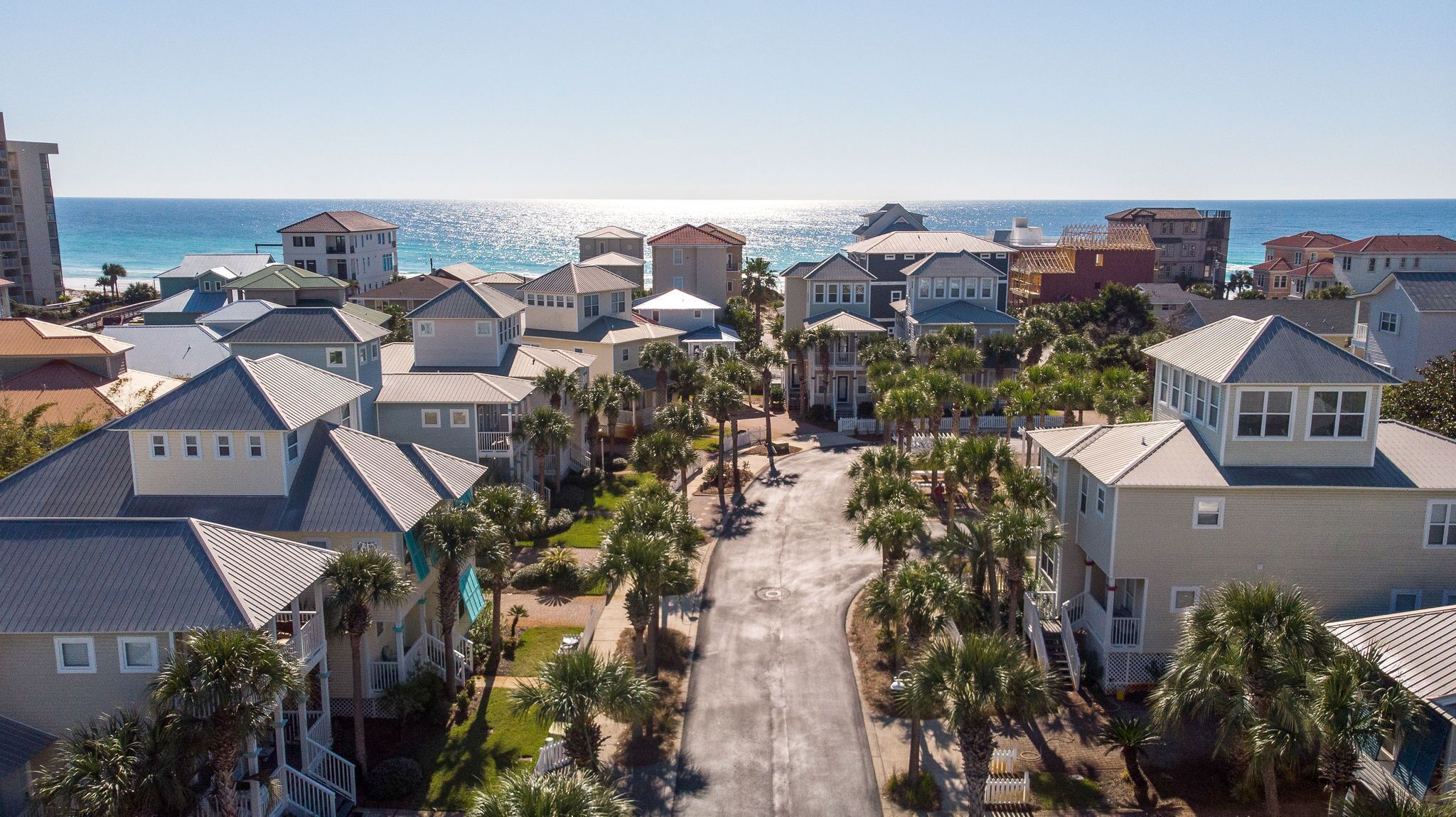 Una zona residenziale sul lungomare, con case, palme e vista sull'oceano.