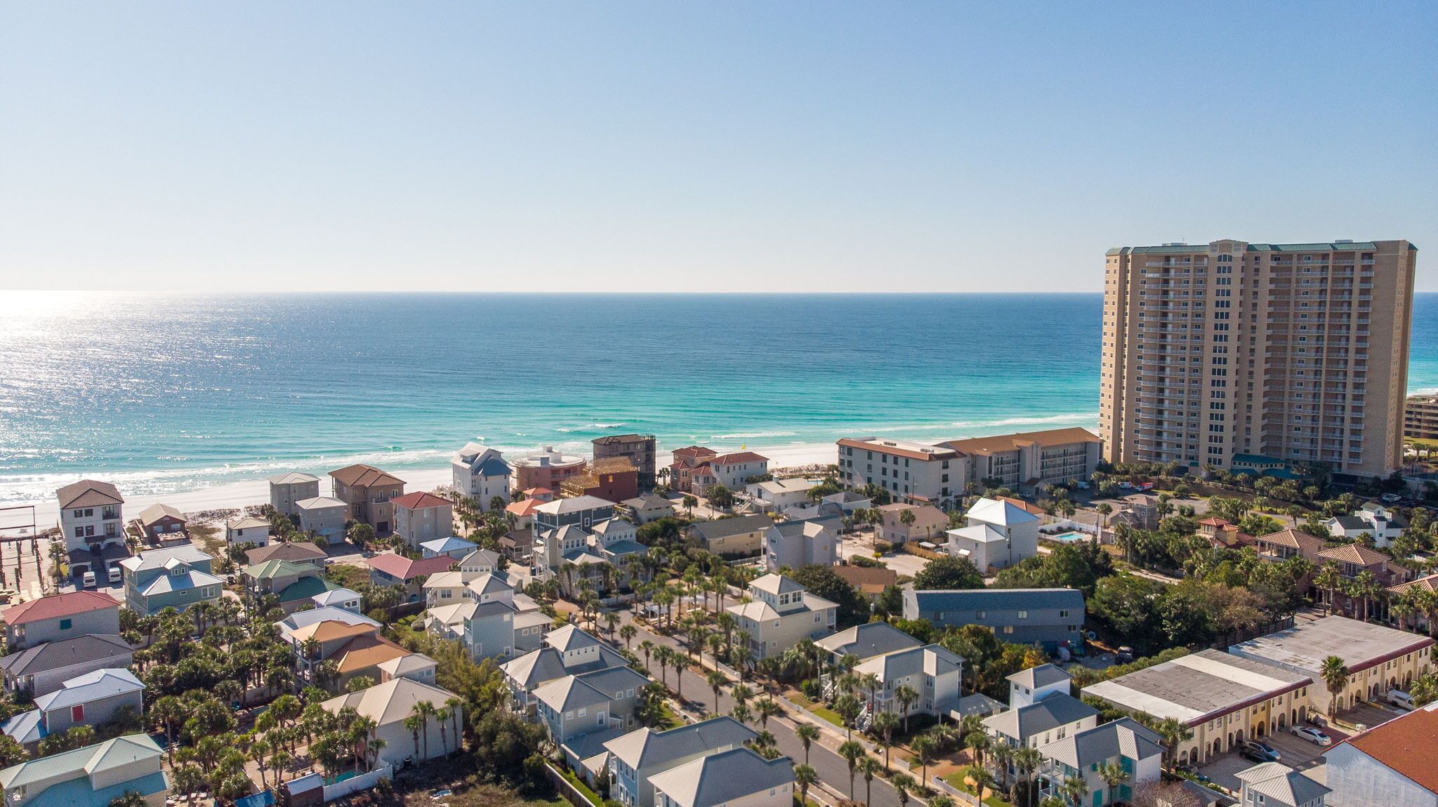 Un quartier résidentiel situé sur la côte, avec un hôtel en bord de mer et un grand immeuble d’hôtel.
