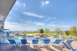 A poolside area with lounge chairs and a view of the ocean. - Armada By-the-Sea (Wildwood Crest)