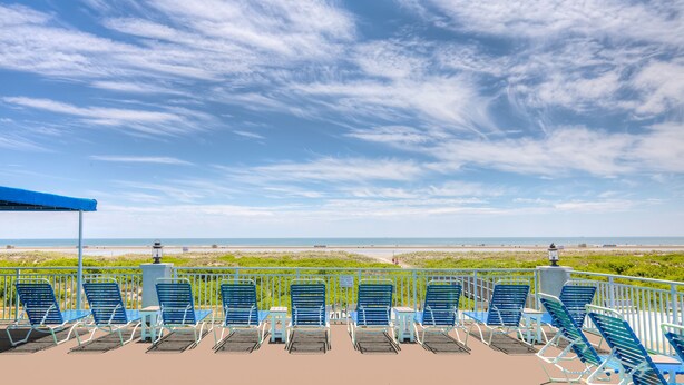 A beachside seating area with blue chairs and a blue canopy, overlooking the ocean. - Armada By-the-Sea (Wildwood Crest)