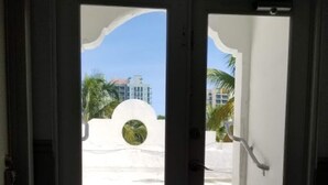 A doorway with a view of a building and palm trees. - SPACIOUS SOBE CORNER ONE BEDROOM---EXCELLENT LOCATION (Miami Beach)