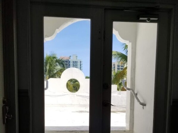 A doorway with a view of a building and palm trees.
