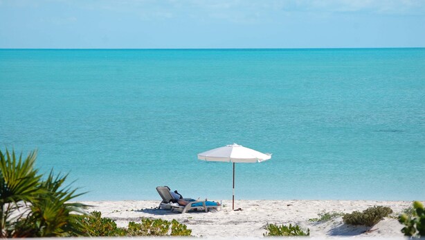 A beach with two sun loungers and a white umbrella. - Stunning 1BR Ocean Vw + Jacuzzi SUV Kite Boarding - Wyakha 4 Ocean View (Long Bay)
