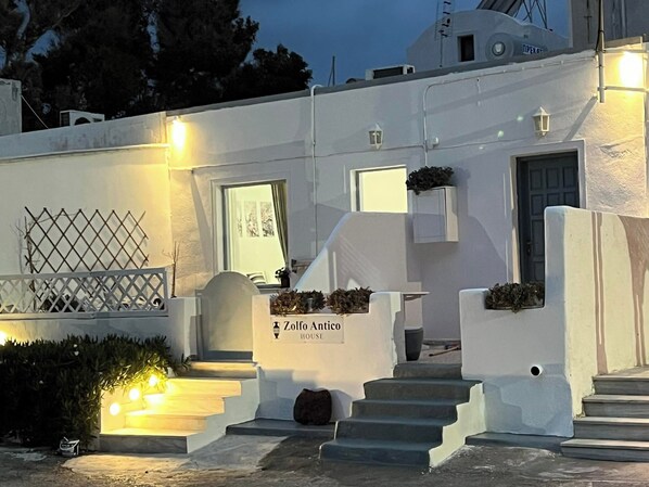 A white building with a sign reading "Zolno Anthico HOUSE" at the entrance. - Sagma Beach Rooms (Santorini)