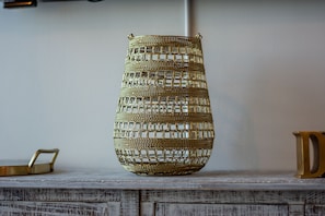 A decorative metal vase with a geometric pattern, placed on a wooden surface.