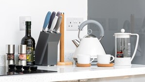 A modern kitchen with a kettle, coffee maker, knife block, and various condiments. - Beautiful Apartment in Central Neighbourhood (Cardiff)