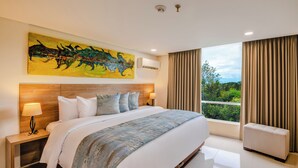 Una habitación de hotel con una cama grande, una mesita de noche, una lámpara, un cuadro en la pared y una ventana con cortinas.